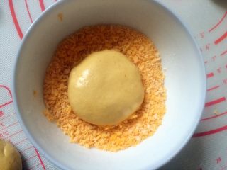 13、#甜味＃南瓜豆沙饼,均匀裹上面包糠。