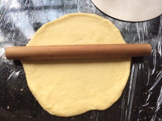 6、河粉披萨,和好的面团取出放到操作台中,用擀面杖擀开成圆形装。