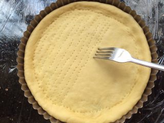 7、河粉披萨,把擀好的面饼放入模具中,用刀叉叉出小孔。