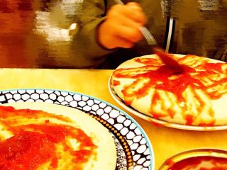 6、DIY亲子披萨,将适量披萨酱分别均匀地涂抹于9寸和6寸的披萨饼上。