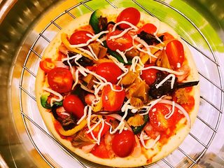 12、DIY亲子披萨,并铺撒适量马苏里拉奶酪并放置于光波炉内的烤架上。