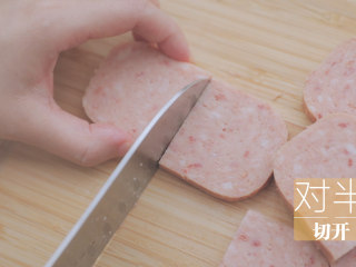 10、春の饭团的2+1种有爱做法「厨娘物语」,午餐肉罐头打开倒出，均匀切片后对半切开，将海苔片剪成细条状备用。