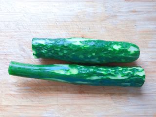 3、凉拌黄瓜,黄瓜随意去皮，洗净。（我的这根黄瓜太长了不好拍照，所以把它切成两断了）