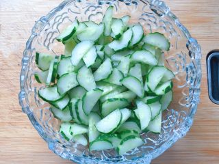 10、凉拌黄瓜,把切好的黄瓜片放入大碗中。