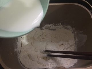 2、披萨蛋糕,饼底材料中的高粉、低粉、盐、糖和酵母倒入面包机桶里，加入纯牛奶，用筷子搅拌成棉絮状