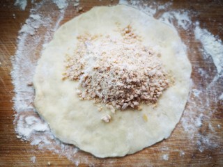 19、红糖酥饼,每块面团在案板上压成面皮,中间厚,边缘薄(为了保证饼的外壳厚度均匀),然后舀上红糖面粉