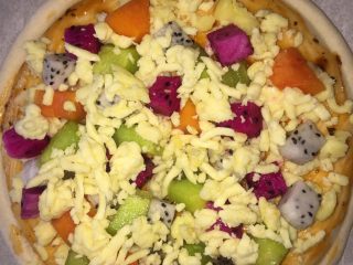 5、#甜味#缤纷水果披萨,然后再铺一层芝士碎