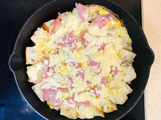 14、吐司培根披萨,盖上锅盖，继续慢火煎至芝士融化，就可以关火了