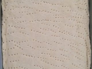 3、烤肠披萨,烤盘预热底部摸黄油备用，自发粉发后杆长方形入烤盘表面用叉扎孔