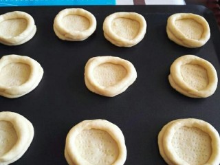 16、米奇沙拉面包,40克的面团用擀面杖擀卷成圆形，用叉子在面团上面戳小孔，然后将长条形贴在面团上面。