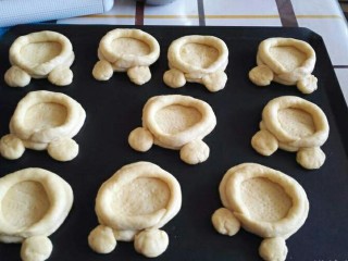 17、米奇沙拉面包,将5克的面团揉圆，放在圆形面团的两边，然后按扁（圆形面团的旁边可以刷一点水，以利米奇的耳朵沾上）