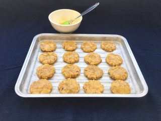14、核桃酥,每个饼干面团用手压扁后，刷上一层蛋液。