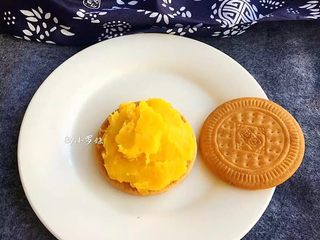 7、夹心南瓜饼,准备饼干两个,一块饼干用勺子码上南瓜泥(码在没有图案一面)