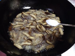 6、香菇菌子油,待香菇炸软出汁后放入适量的盐（约5克左右）继续炸