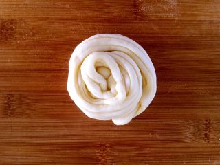 18、发面盘丝饼,把长条从一头向另一头卷起。，卷成圆形。