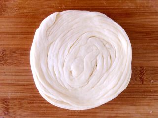 19、发面盘丝饼,卷好的面团用手按扁。擀薄。