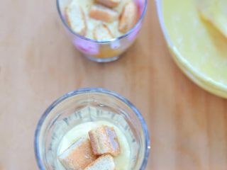 9、芒果冻芝士,然后再加入一部分冻芝士糊，加入切碎的手指饼，再重复倒入冻芝士糊，直到芝士糊完全用光。另一杯也是同样的做法。 