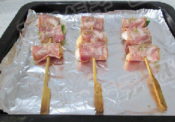 4、培根蔬果卷,放入烤盘中，撒上适量披萨草碎