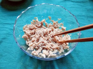 4、金枪鱼沙拉,把金枪鱼肉倒进一个大的沙拉碗，用筷子打散，放在一旁备用。