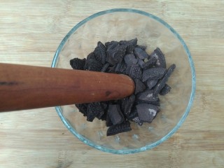 5、奥利奥酸奶盆栽,然后用擀面杖的一头把它捣碎。（我家没有捣碎的专用工具，只能用此法，捣蒜也很好用哟！）