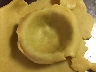 4、流心芝士挞(最省时无需冷冻配方),取一个蛋挞模,将面皮放进去,使面皮和蛋挞模贴合在一起,去掉边缘部分。