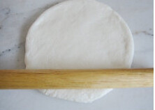 2、台湾香肠什蔬批萨,将发酵好的面团排气，滚圆，松弛10分钟以后再擀，擀成批萨盘大小的圆片