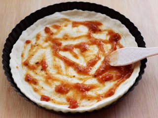 5、培根青豆披萨,烤箱190度提前预热5分钟后，把做好的披萨面皮放入烤箱，175度烤制5分钟后，加入披萨酱后，用铲子把披萨酱抹均匀。