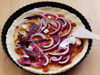 6、培根青豆披萨,加入提前切好的洋葱片，均匀地铺在披萨皮上面。