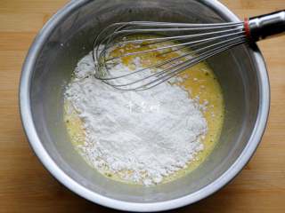 4、香浓蛋奶黄金豆,将低筋粉筛入或直接倒入搅匀的蛋液中，用蛋抽呈Z字形或无规则方向搅动。