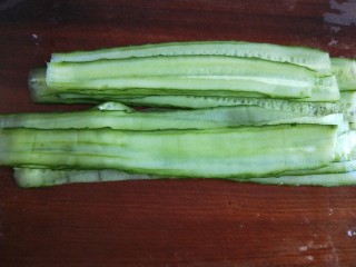 13、凉拌黄瓜卷,黄瓜用刮皮刀刮成片。