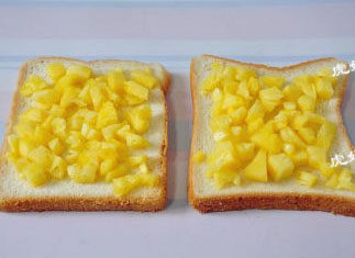 6、傻白甜式快手早餐：菠萝虾仁披萨 ,将菠萝丁均匀的铺在土司面包片上。