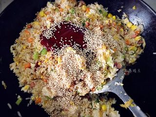 5、韩式焗饭,将菜、蛋及饭翻炒均匀，放入辣酱及白芝麻翻炒均匀。