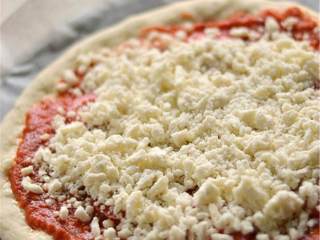 4、玛格丽特披萨,抹上番茄酱 ，放上中等大小的番茄（切片）（1个），撒上马苏里拉芝士碎 以及任意你喜欢的香草。