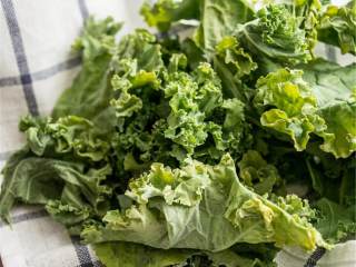 4、意大利式南瓜菠菜玉米饼披萨,洋葱炒好之后，从锅中盛出备用；锅中再放入羽衣甘蓝 ，中火炒4-5分钟，到叶子变软。