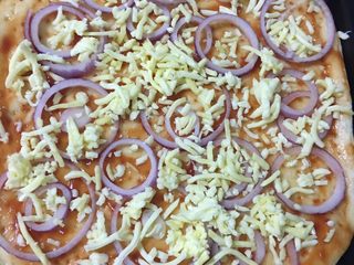 4、披萨,先涂抹上一层番茄沙司，再摆一些洋葱，再撒上适量的奶酪。