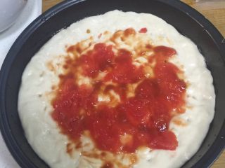 9、香肠披萨,把烫好的番茄切蒂撕皮，尽力挤干水份平铺发好的面皮中间，在滴一些番茄酱，这样味道不会太酸也比较鲜。