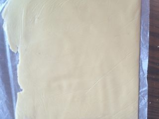 8、炼乳饼干,装入保鲜袋内，用擀面杖擀成厚度约0.3-0.4cm 的薄片，放冰箱冷冻30分钟。