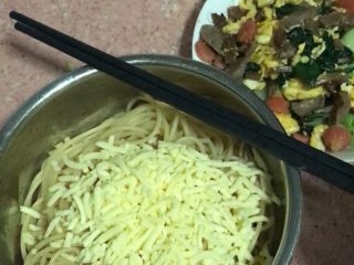 5、番茄酱芝士意大利面,趁面条温度比较高的时候,再在面条的表面撒入芝士碎条(⚠️注意:撒芝士条的时候一定要在面条刚刚出锅的时候放入才可以,因为这样才能让芝士碎条融化成粘稠状)