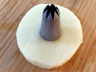 6、苹果甜甜圈,取一片苹果，把裱花嘴放在苹果核上，用力往下压