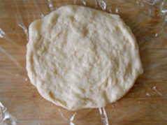 4、番茄肉酱披萨 ,发好的面团放案板上擀成圆形