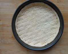 5、番茄肉酱披萨 ,披萨盘涂黄油，擀好的面皮放入披萨盘，压一压，让面皮贴合，在面团底部用叉子叉一些小孔