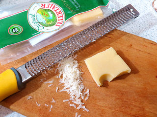 1、浓郁味香的【培根奶油炖菜】,首先制做白酱。将大孔奶酪磨成细碎状