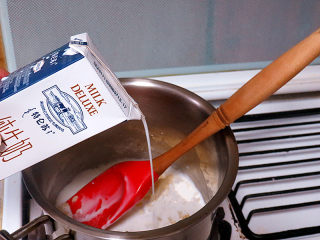 4、浓郁味香的【培根奶油炖菜】,炒至面粉稍微冒小泡泡之后分两次倒入牛奶，不停地搅拌