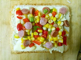 7、简易快手早餐～吐司披萨,铺上炒好的蔬菜丁。