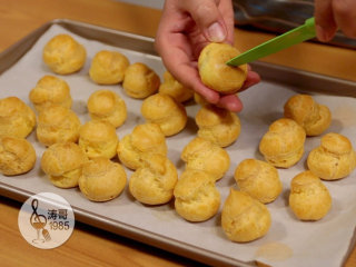 27、让世上没有难做的泡芙,从烤箱里取出冷却好的泡芙，用小刀在泡芙底部切个十字口来挤填充，我这次是在底部挤，发现不太好挤，你也可以考虑从表面裂缝处开口挤填充，那样会更好