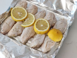 8、柠檬黑胡椒烤鸡翅,摆上前面切好的柠檬片。腌制鸡翅的汤水倒掉！！不要一起倒进来！！