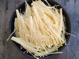 2、锡纸蒜蓉烤金针菇,将金针菇去头洗干净撕碎放入8寸披萨盘中