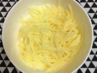 1、土豆丝培根披萨,土豆去皮洗净擦成丝，洗去淀粉沥干，装入碗中。