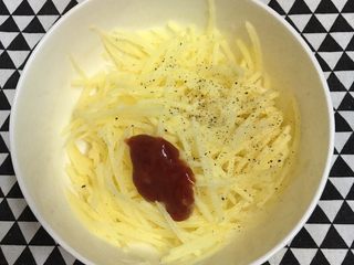 2、土豆丝培根披萨,调入盐和细砂糖，再加入黑椒粉和番茄酱，用筷子搅拌均匀。