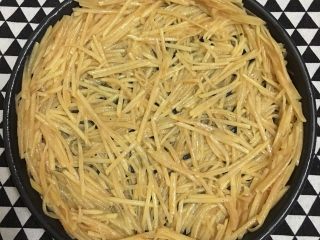 3、土豆丝培根披萨,披萨盘抹一层黄油或食用油，将拌好的土豆丝铺入披萨盘中。